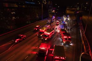 Police, fire and EMT personnel respond to two people who were seriously injured when a car sped through a protest gathered on the closed Interstate 5 near the Yale Avenue on-ramp in Seattle in the early morning hours of Saturday. (James Anderson / Special to The Seattle Times)