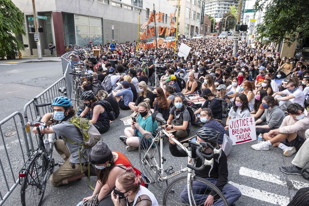  Seattle Youth Protest participants sit at Ninth Avenue and Virginia Street, outside the Seattle police’s West Precinct, for 8 1/2 minutes last month. That’s the length of time a white Minneapolis police officer knelt on... (Dean Rutz / The Seattle Times 