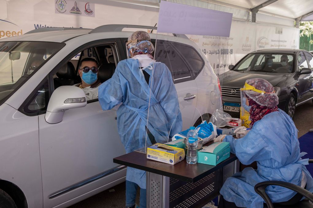 In Cairo, Egypt, a health worker prepares to take swab samples to test for the coronavirus at a drive-through screening center on June 17, 2020. (AP Photo/Nariman El-Mofty)