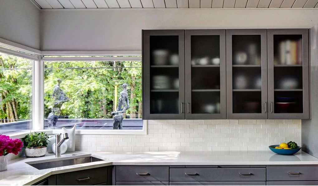 To update this kitchen, designer Sara Wise repainted the cabinets a medium gray, changed the cabinet glass and added new counters, backsplash and hardware. (Courtesy of Sara Wise)
