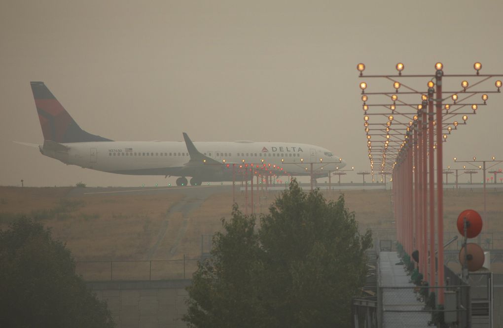 Through thick haze from fires, a plane taxis to a runway at Seattle-Tacoma International Airport Sept. 15. (Ellen M. Banner / The Seattle Times)