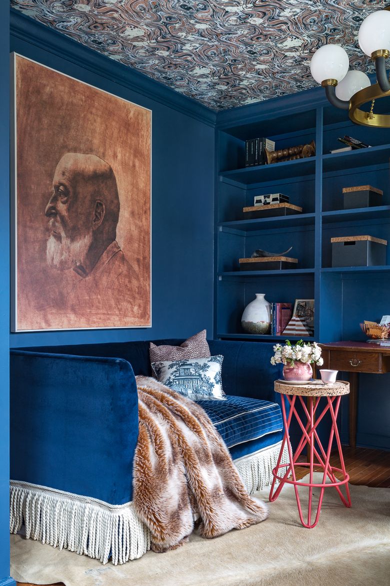 Jewel Marlowe painted her home office in Farrow & Ball Stiffkey Blue and covered the ceiling with Spoonflower wallpaper. She accessorized the space with artwork from Minted and a glamorous fixture by Hudson Valley Lighting. (Jewel Marlowe)