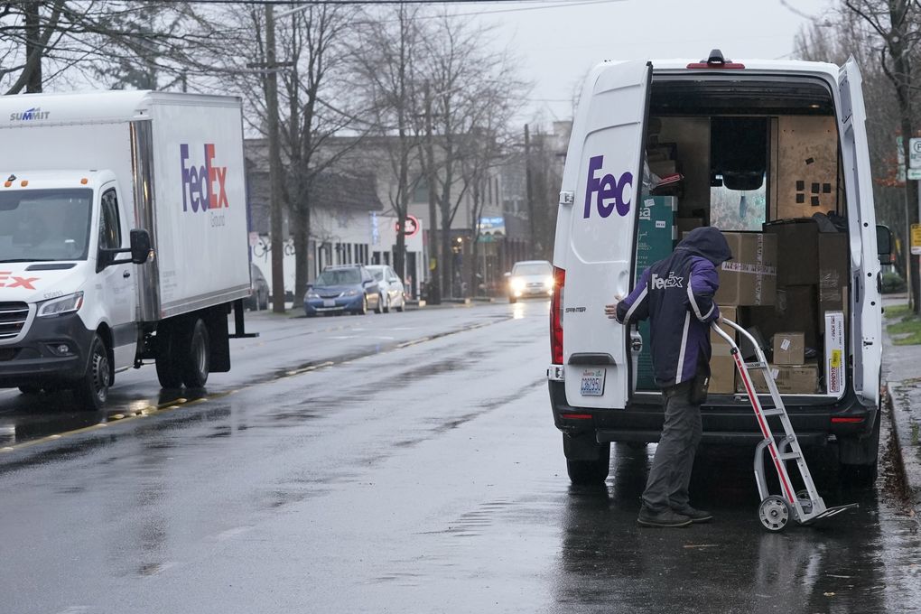 A driver with FedEx gets ready to make a delivery last month in Seattle. The Seattle area saw a huge uptick in online shopping because of the coronavirus pandemic. (Ted S. Warren / The Associated Press)