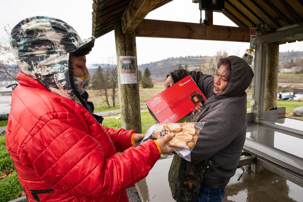 Lana Jack, left, donates a pair of warm gloves and a heater to Althea McConville. (Andy Bao)