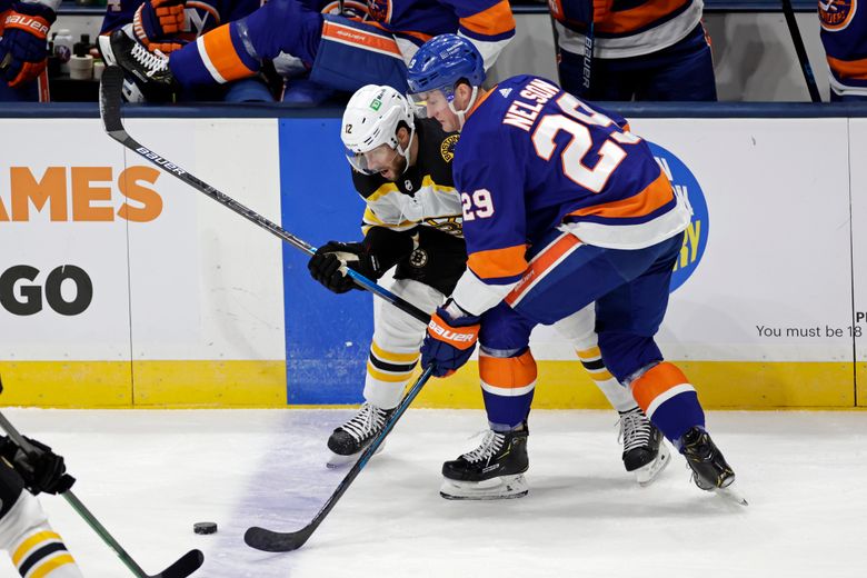 New York Islanders center Brock Nelson (29) battles for the puck with Boston Bruins right wing Craig Smith during the first period of an NHL hockey game, Thursday, Feb. 25, 2021, in Uniondale, N.Y. (AP Photo/Adam Hunger)