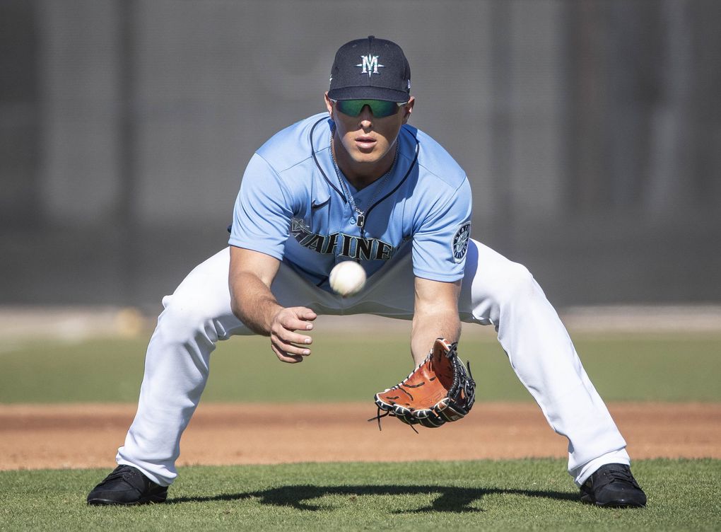 Dylan Moore fields grounders during a spring training practice on Thursday, Feb. 20, 2020.  (Dean Rutz / The Seattle Times)