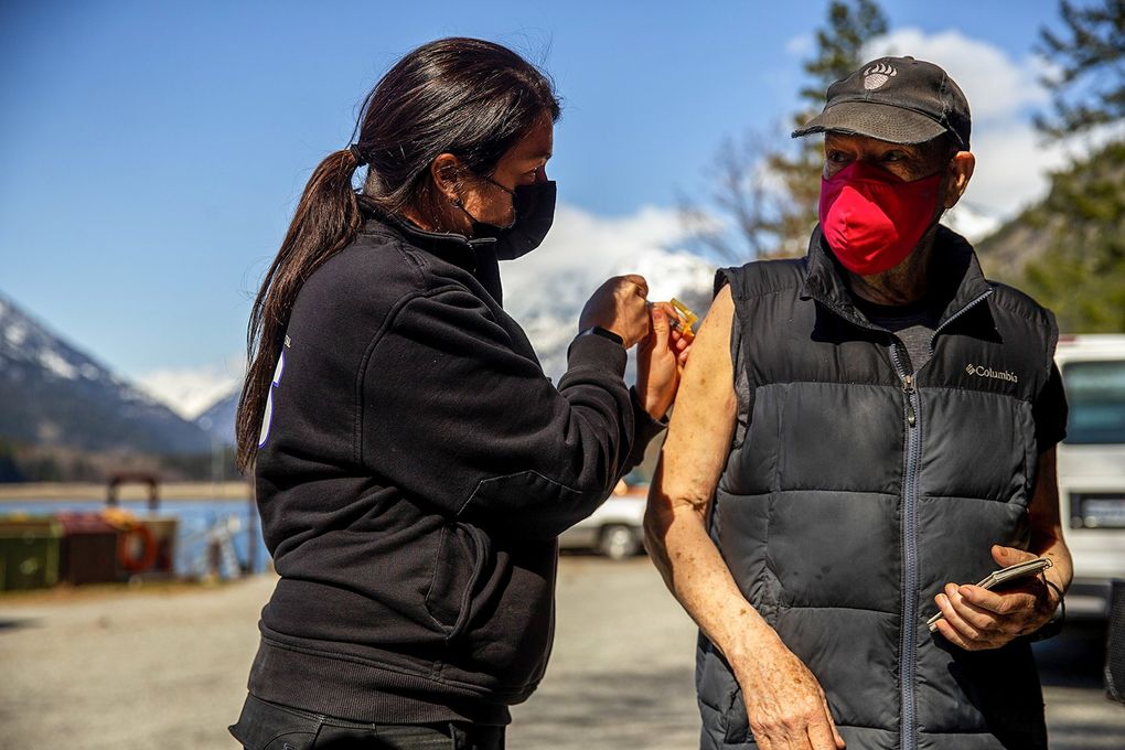 Stehekin resident Billy Sullivan, right, is adminstered the Moderna COVID-19 vaccine by paramedic Mistaya Johnston on March 30. (Amanda Snyder / The Seattle Times)