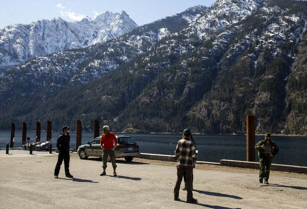 Stehekin residents space out on the boat landing on March 30. Some were either waiting their turn for the vaccine shot or were resting for a moment after receiving the vaccine. (Amanda Snyder / The Seattle Times)