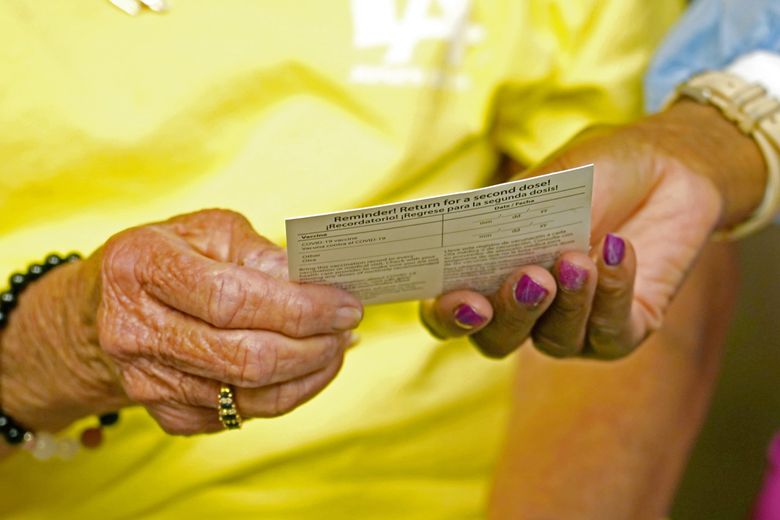 Linda Busby, 74, receives a COVID-19 vaccination card after getting a shot at a community health center April 7, 2021, in Clarksdale, Miss. (Rogelio V. Solis / The Associated Press)