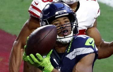Wide receiver Tyler Lockett #16 of the Seattle Seahawks catches the game winning touchdown over cornerback Ahkello Witherspoon #23 of the San Francisco 49ers during the fourth quarter at State Farm Stadium on January 03, 2021 in Glendale, Arizona. (Photo by Chris Coduto/Getty Images)