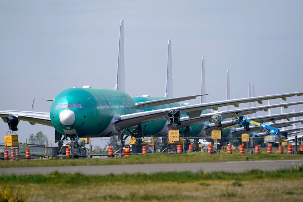 A line of Boeing 777X jets are parked nose to tail on an unused runway at Paine Field, near Boeing’s massive production facility, Friday, April 23, 2021, in Everett, Wash.  Boeing Co. on Wednesday, April 28,  reported a loss of $537 million in its first quarter. The Chicago-based company said it had a loss of 92 cents per share. Losses, adjusted for non-recurring gains, were $1.53 per share.  (AP Photo/Elaine Thompson)
