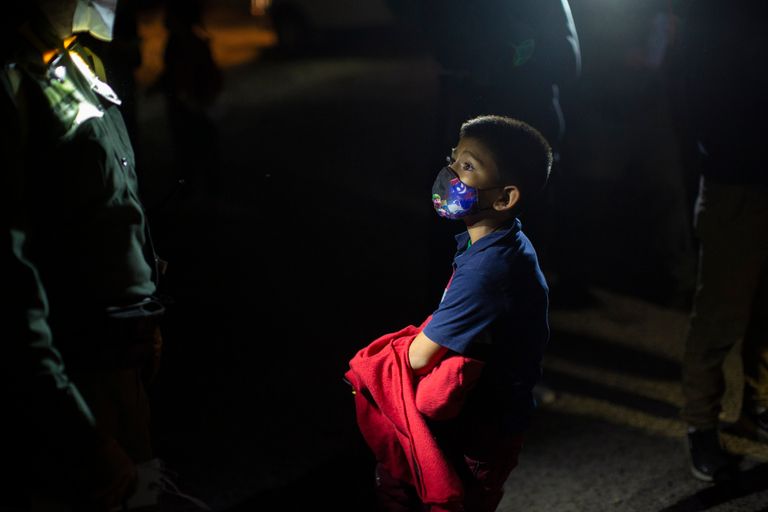A child traveling from El Salvador hoping to reach relatives living in the U.S. answers questions from a U.S. Border Patrol agent after he was smuggled across the Rio Grande river in Texas on March 24, 2021.
