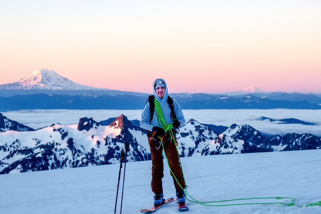 Cal’ Smith grasps his rope while ski mountaineering on Mount Rainier in June 2020 with Mount Adams and Mount Hood looming in the background.  (Micheli Oliver)