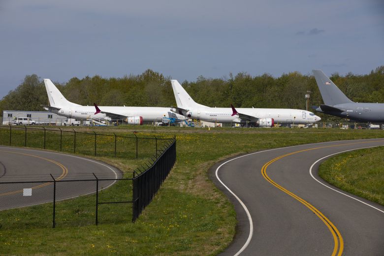 An Air Force tanker (at right) and two “white tail” 737 MAXs are parked on a short runway at the north end of Paine Field in April. (Ellen M. Banner / The Seattle Times)