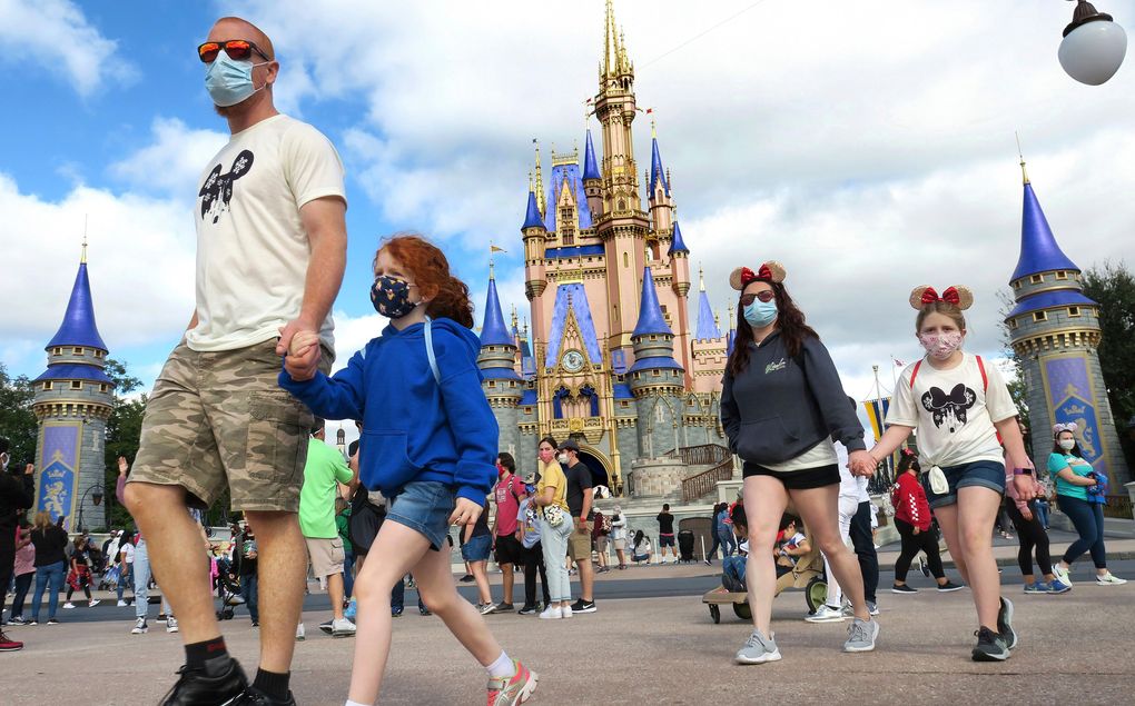 FILE – IN this Dec. 21, 2020 file photo, A family walks past Cinderella Castle in the Magic Kingdom, at Walt Disney World in Lake Buena Vista, Fla. Florida’s major theme parks are adjusting their face mask policies after the federal government loosened its recommendations as more people get vaccinated for the coronavirus. Visitors to Walt Disney World and Universal Studios-Orlando were allowed Saturday, May 15, 2021 to remove their masks when they are outdoors except when they are on attractions, in line or riding a tram or other transportation.(Joe Burbank/Orlando Sentinel via AP, File)