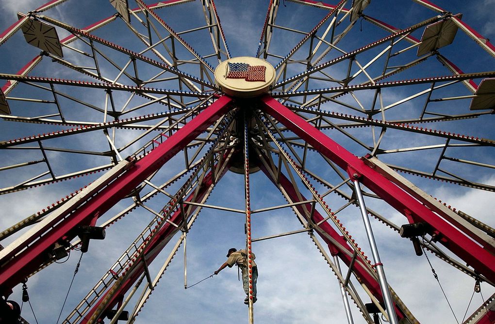 A carnival worker helps assemble the ferris wheel at the Grant County Fairgrounds in Moses Lake. Officials announced this week that the fair will go ahead at full capacity in summer 2021. (Jerome A. Pollos / Coeur d’Alene Press via AP, 2005)