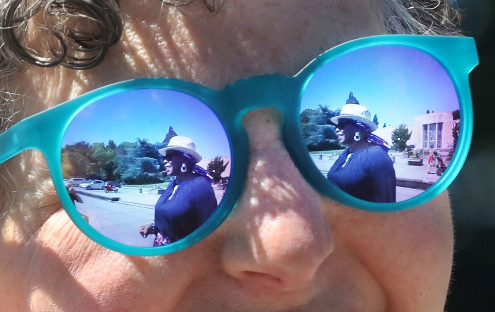 Vivian Phillips is reflected in podcast partner Marcie Sillman’s sunglasses at Volunteer Park on Capitol Hill. The two have teamed up to create an arts and culture podcast called  “DoubleXposure.” (Alan Berner / The Seattle Times)