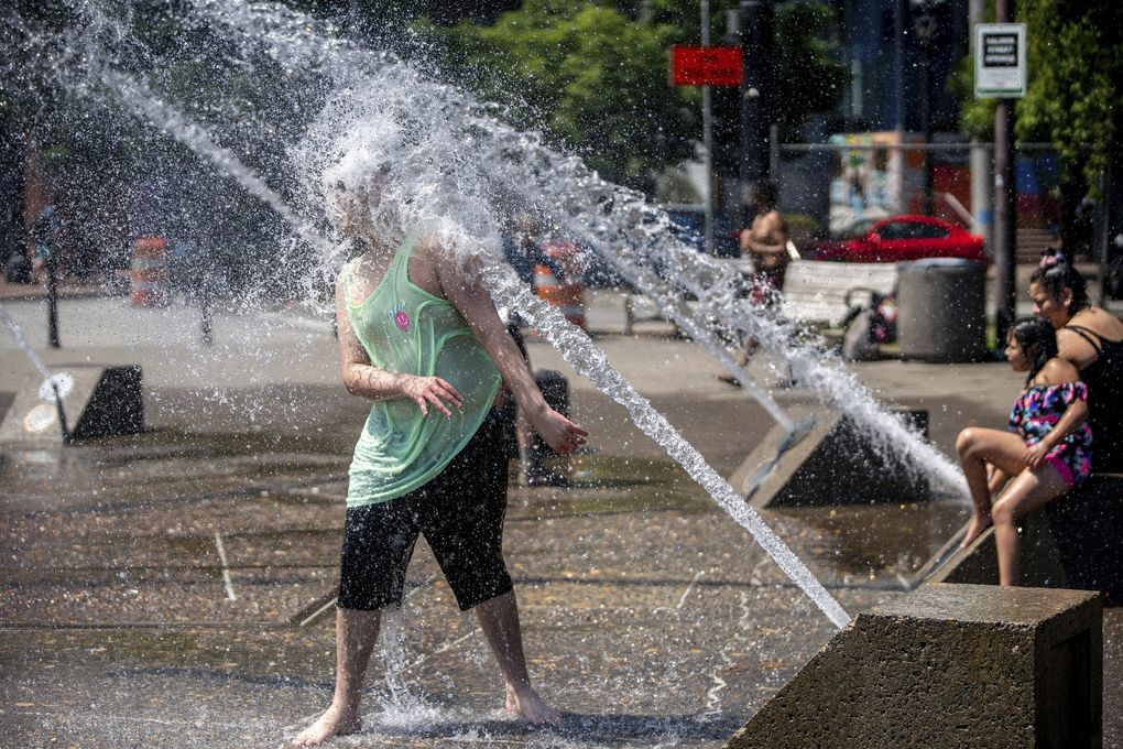 While Portland reached a record temperature of over 110 degrees on Sunday, people gathered at the Salmon Street Springs water fountain to cool off. (Mark Graves / The Associated Press)