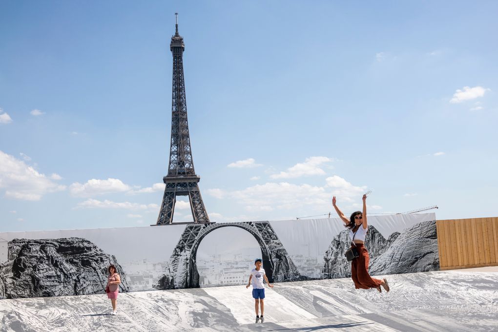 People and families enjoy the nice weather at the Trocadero were an art piece by French photographer JR was set up, Wednesday, June 16, 2021 in Paris. Temperatures rose up to 33 degrees Celsius (91 degrees Fahrenheit) in the French capital. (AP Photo/Benjamin Girette)