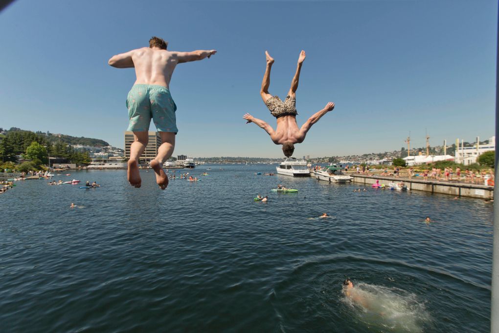Two people jump from a pedestrian bridge at Lake Union Park into the water during a heat wave hitting the Pacific Northwest, Sunday, June 27, 2021, in Seattle. Yesterday set a record high for the day with more record highs expected today and Monday. (AP Photo/John Froschauer)