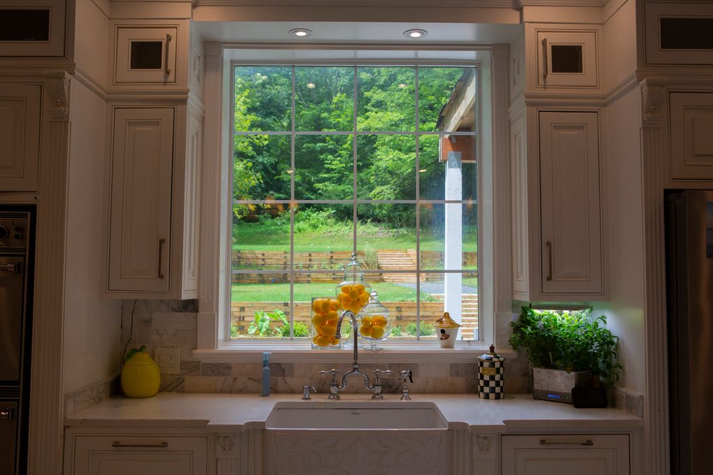 The fireclay kitchen sink features an embossed apron front and a bridge faucet. (Calla Kessler for The Washington Post)