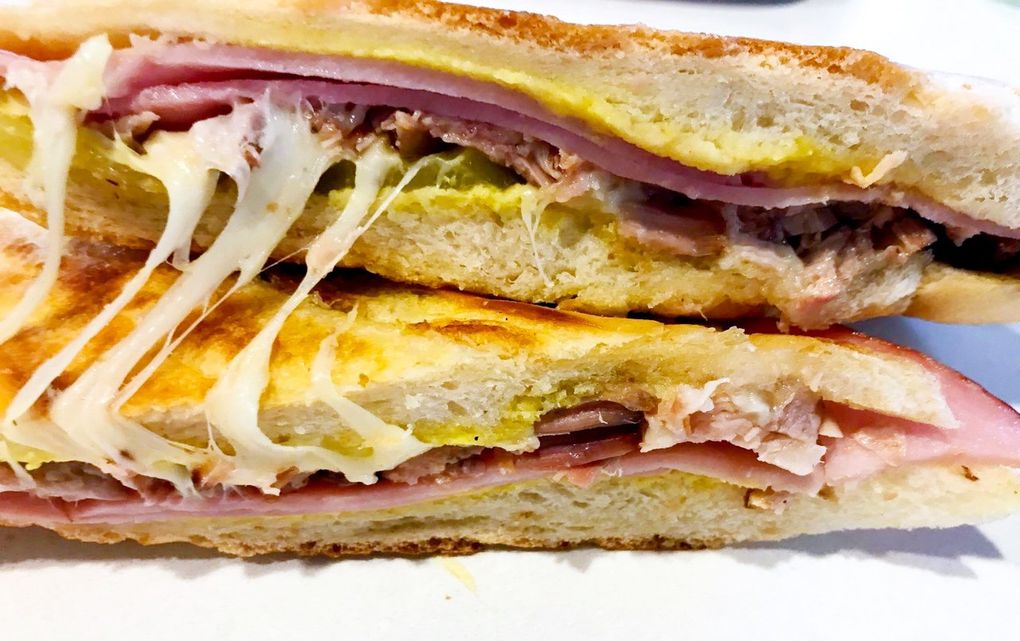 The $10  “Classic Cubano” at El Cubano in Shoreline is a pressed sandwich layered with hickory-smoked ham, roast pork, pickles and melted Swiss cheese.  (Tan Vinh / The Seattle Times)
