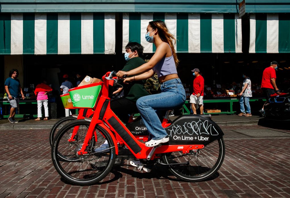 Bicyclists and pedestrians pass Pike Place Market in Seattle last week. (Erika Schultz / The Seattle Times)