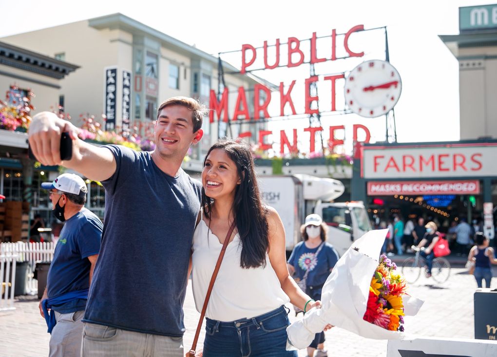 Jordan Silver and Michelle Lara, of San Diego, take a selfie at Pike Place Market on Thursday. (Erika Schultz / The Seattle Times)
