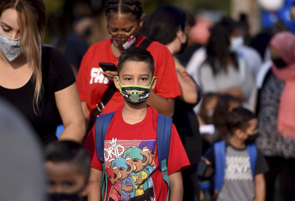 Students and parents wait in line to enter the Normont Early Education Center for the first day of school in Harbor City, Calif., on Monday. 
 (Brittany Murray / The Associated Press)