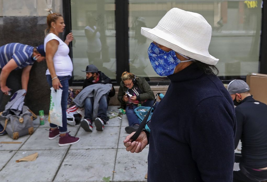 Cynthia Marin, foreground, walks along Third Avenue, a street she has been avoiding because of the now-common drug use, crime and other safety issues, there. (Ken Lambert / The Seattle Times)