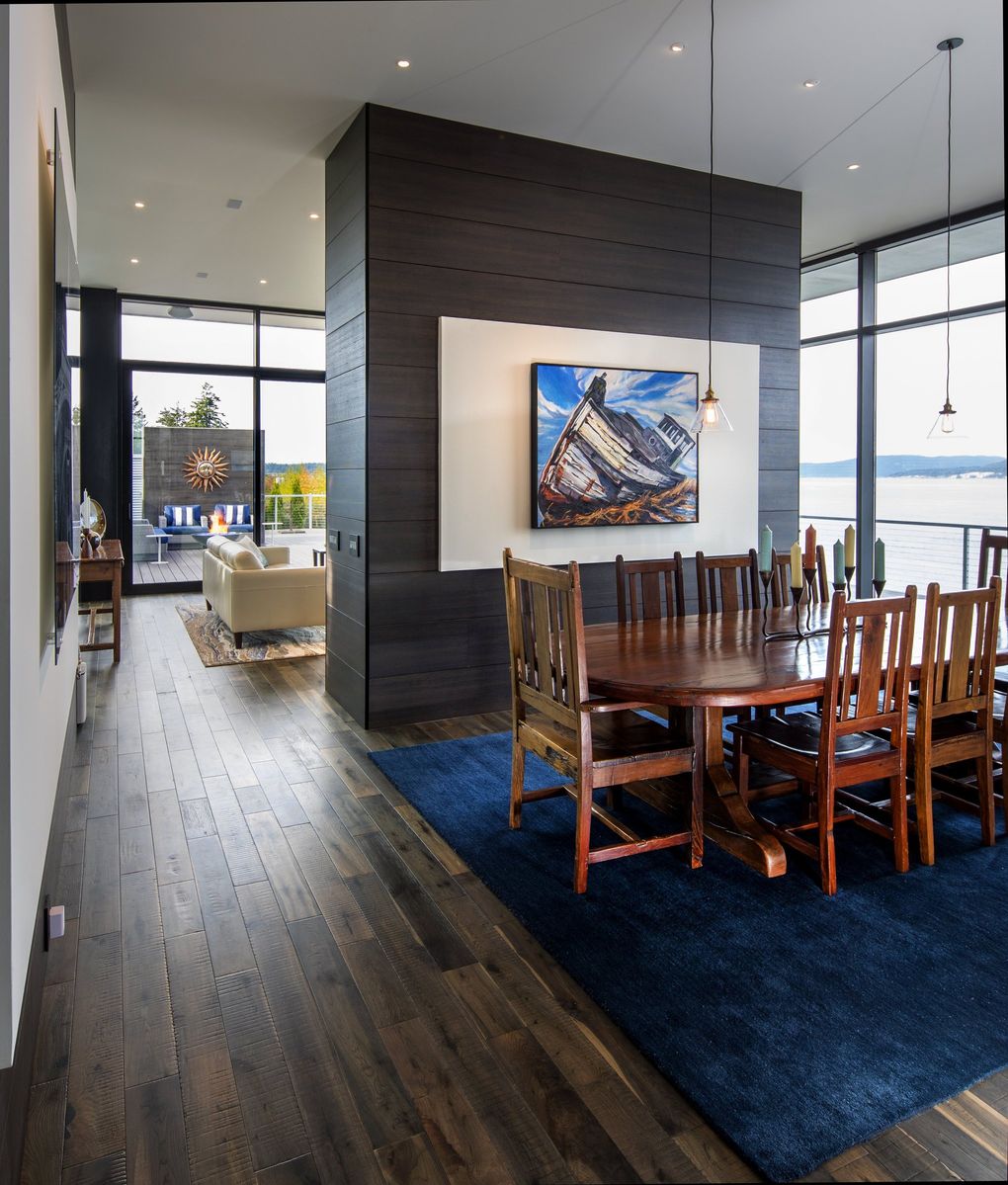 The dining and living areas of The Cliff House in Anacortes are separated by a wall that frames a painting of a shipwreck on Sheetrock, which pops out from CLEAF paneling made in Italy, says architect Brooks Middleton. The paneling also shows up on the kitchen cabinets, but in a different color. (Mike Siegel / The Seattle Times, 2018)