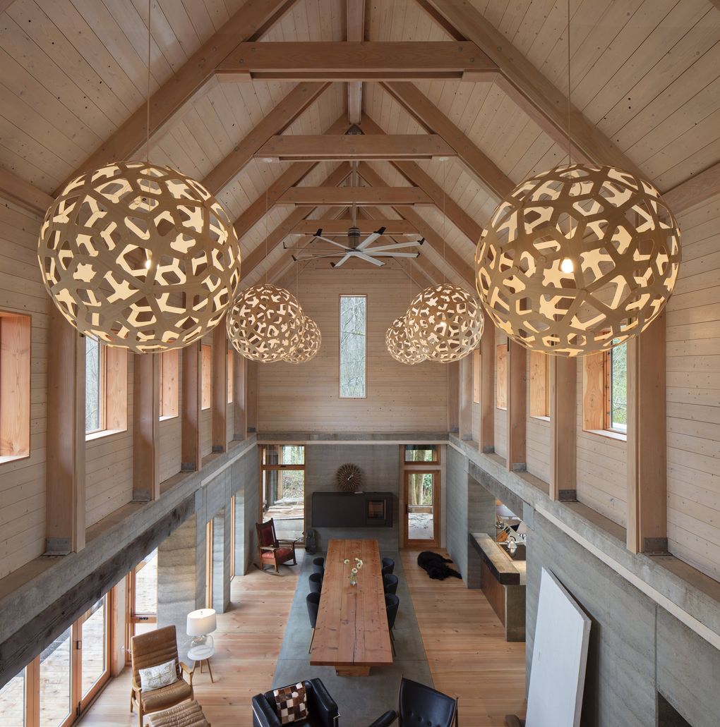 The upstairs kids’ loft of Heron Hall on Bainbridge Island overlooks the cathedral-like great room, with giant salvaged beams and columns from the island, a Big Ass Fan (“It’s a heck of an air-mover,” says designer Jason F. McLennan) and the only deliberately imported element in all of Heron Hall: David Trubridge lights ordered from New Zealand that come flat-packed in a tiny box.  (Steve Ringman / The Seattle Times, 2017)