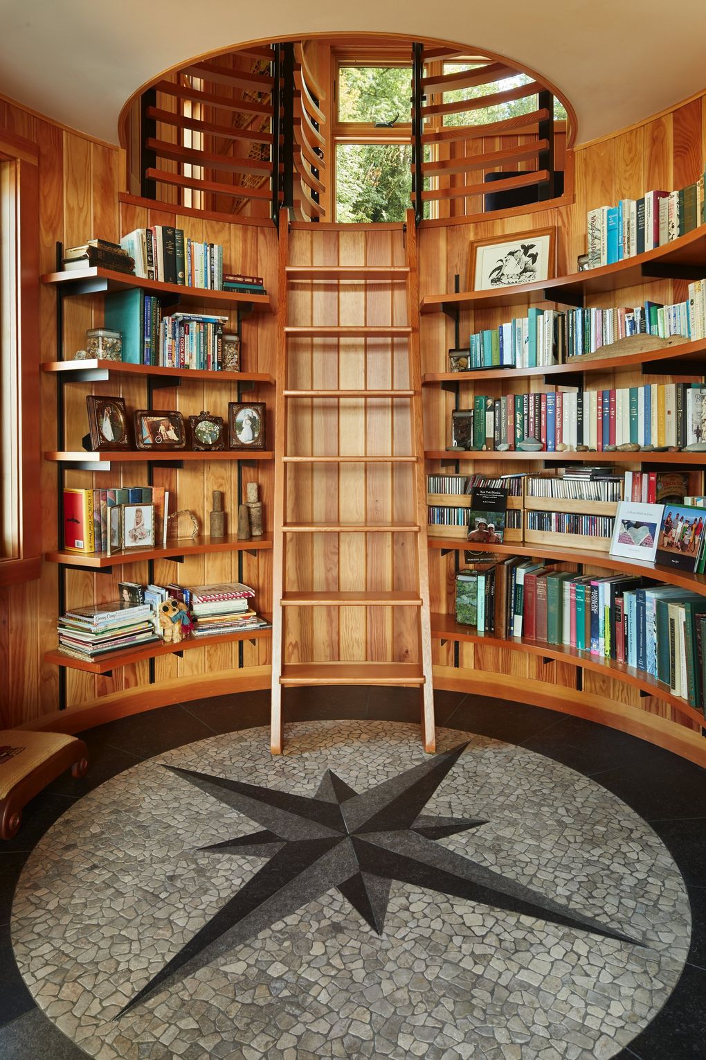 A can’t-miss mariners compass anchors the beautifully curved library of this Hood Canal home. “Since there was only one place for books, we wanted it to be special,” says architect Greg Belding. “The house is a box with a few angles; it felt right to have a circular element — different and special.” (Benjamin Benschneider / The Seattle Times, 2016)