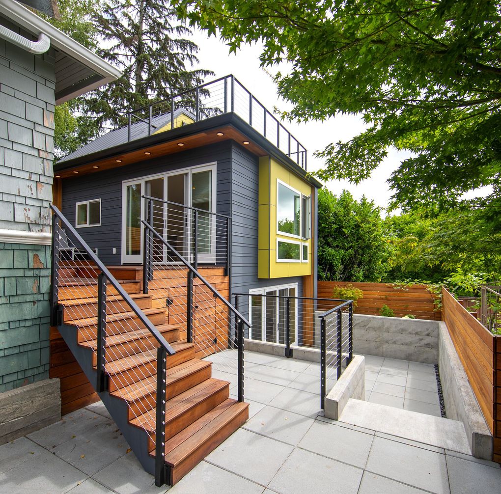 This new detached accessory dwelling unit (DADU) is connected to the century-old main house in Ravenna via a new deck, with cable-railing stairs leading to the sunken patio, where sliding glass doors open to a guest bedroom/workshop and bath. There’s a 200-degree view from the top deck, accessed by an awesome yellow popup  loft space. (Mike Siegel / The Seattle Times, 2019)