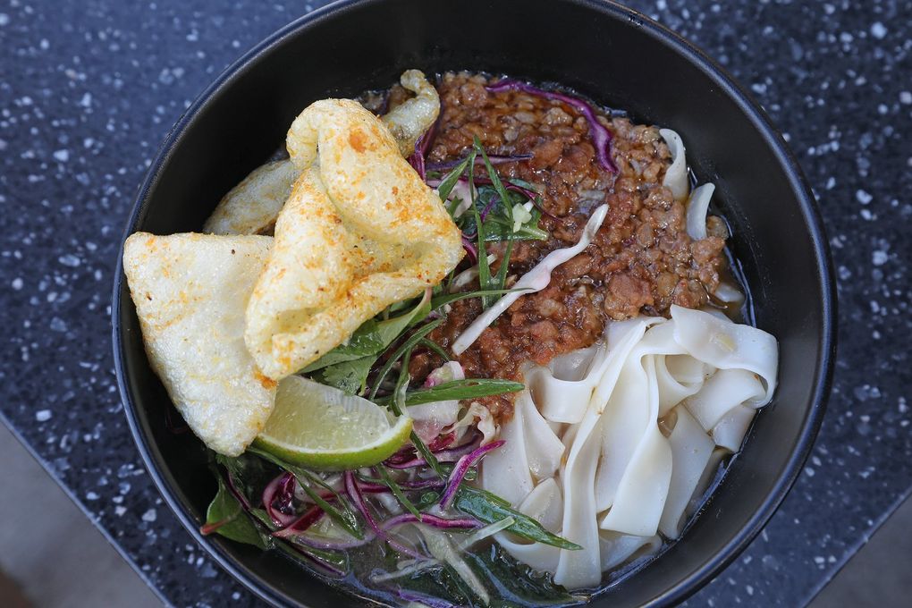 At Taurus Ox, a Laotian restaurant on Capitol Hill in Seattle, you’ll find this khao soi noodle soup with pork broth, meat sauce, ground pork and more, including in-house pork rinds. (Greg Gilbert / The Seattle Times)