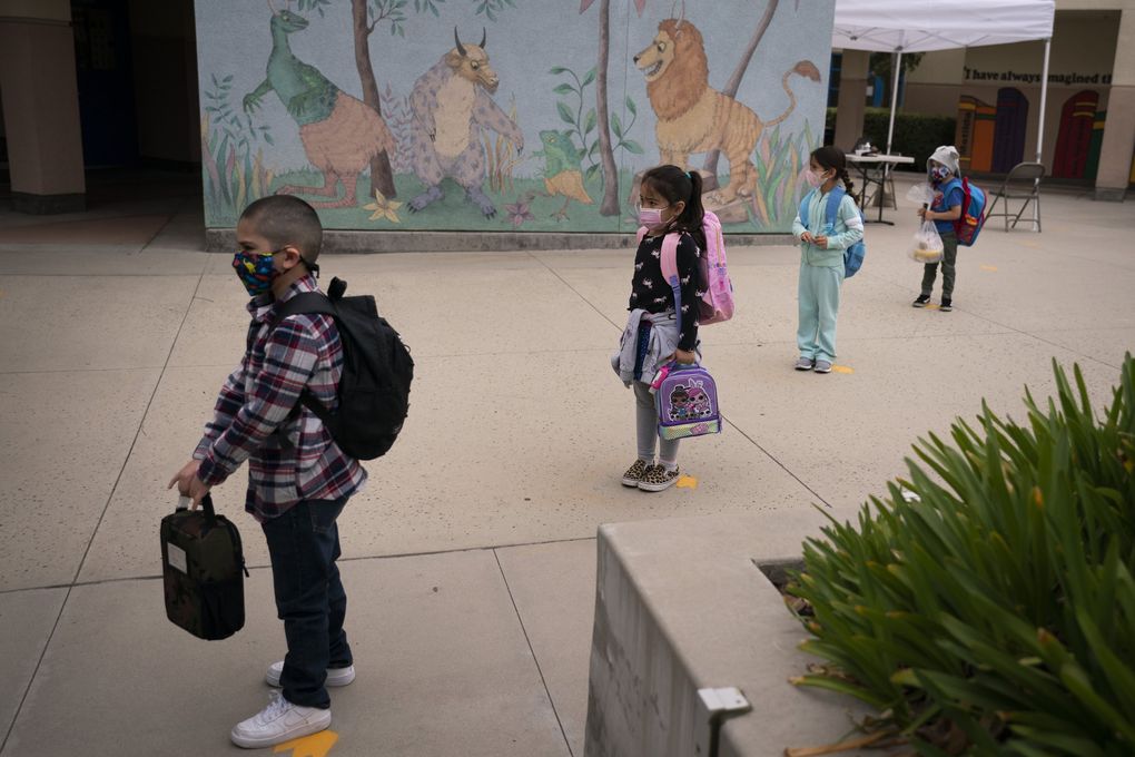Socially distanced kindergarten students wait for their parents to pick them up from a Los Angeles elementary school in April 2021. (Jae C. Hong / The Associated Press)