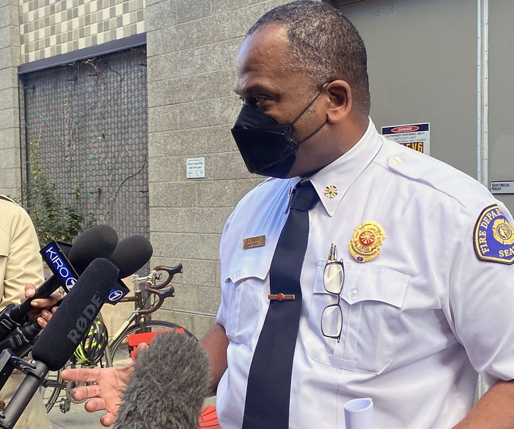 Seattle Fire Department Chief Harold Scoggins answers questions about employee vaccine mandate compliance outside of Cafe Allegro on Monday. (Sarah Grace Taylor / The Seattle Times)