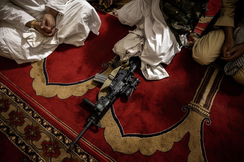 Khalil Haqqani, a high-ranking Taliban leader, keeps an M4 carbine handy during Friday prayers in Kabul on Aug. 20, 2021. The Taliban seized troves of American weapons and vehicles from surrendering Afghan soldiers.  (Jim Huylebroek / The New York Times)