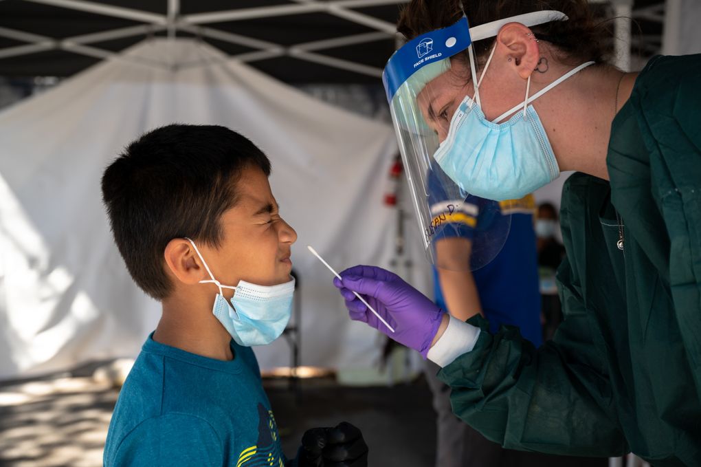 A healthcare worker administers a COVID-19 test on a child in the Mission District of San Francisco in August. (Mike Kai Chen/The New York Times)