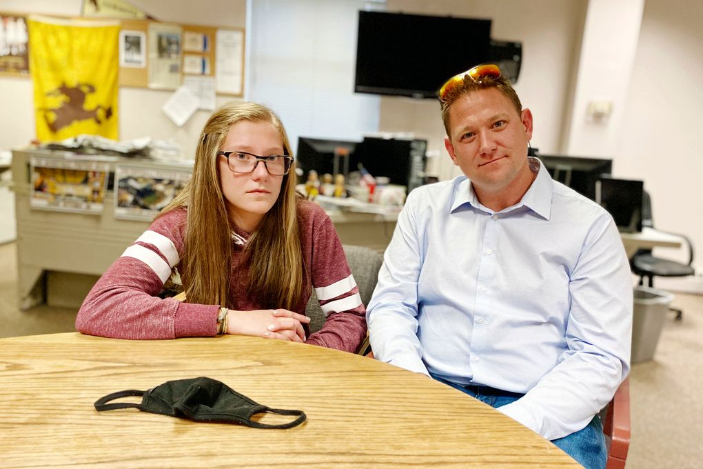 High School junior Grace Smith, 16, and her father Andy Smith poses in the Laramie Boomerang newsroom in Laramie Wyo., Thursday, Oct. 7, 2021. Police had arrested Grace Smith earlier that day when she violated a school mask mandate and allegedly refused to leave Laramie High School. The school district voted Wednesday Oct. 13, 2021, to extend the mask mandate another month. (Greg Johnson/Laramie Boomerang via AP)