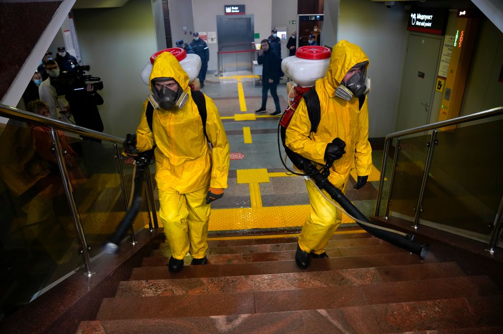 Employees of the Federal State Center for Special Risk Rescue Operations of Russia Emergency Situations disinfect the Savyolovsky railway station in Moscow, Russia, Tuesday, Oct. 26, 2021. The daily number of COVID-19 deaths in Russia hit another high Tuesday amid a surge in infections that forced the Kremlin to order most Russians to stay off work starting this week. (AP Photo/Alexander Zemlianichenko)