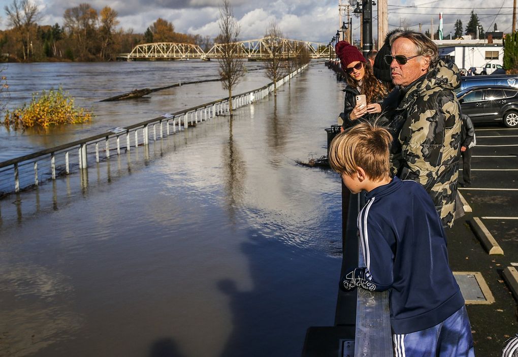 Stewart Erholm and his family check the Skagit River as the water rises to the seawall along downtown Mount Vernon, Wash.