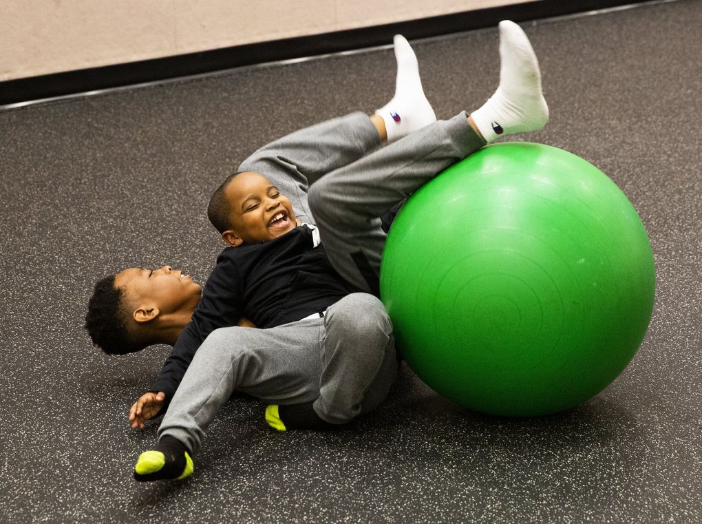 Josiah, 12, plays with her brother Samari, 5, in Childhaven.  (Daniel Kim / The Seattle Times)