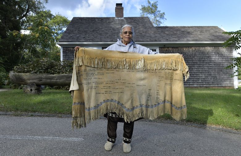 Anita Peters, a Mashpee Wampanoag who goes by her traditional name Mother Bear, holds a deerskin shawl that traces her ancestors back to 1580 outside the Mashpee Wampanoag Indian Museum in Mashpee, Mass., on September 29, 2021. (Photo for The Washington Post by Josh Reynolds).